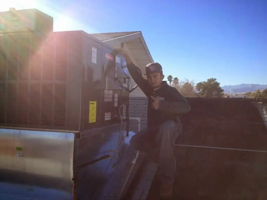 HVAC technician performing Heat Pump Repair on a rooftop unit in Kalamazoo